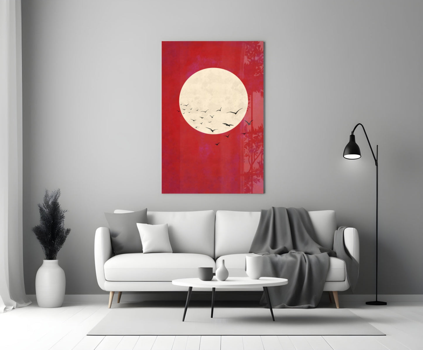 Red glass wall art with cream moon and flying birds displayed above white sofa in modern living room.