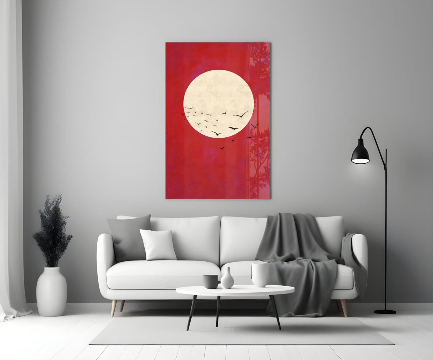 Red glass wall art with cream moon and flying birds displayed above white sofa in modern living room.