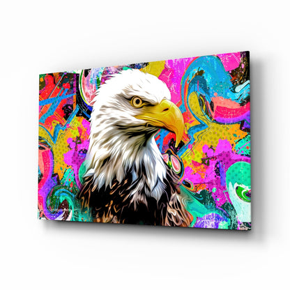 Colorful glass wall art displaying a bald eagle with white head and yellow beak against vibrant multicolored abstract background in magenta, cyan, and yellow tones.