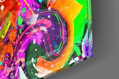 Colorful glass wall art featuring a vibrant monkey face with purple, pink, orange, and green swirling patterns, photographed at an angle against gray background.