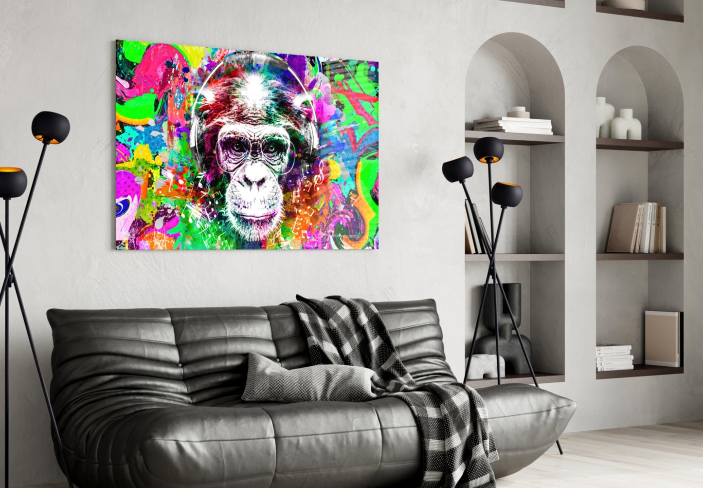 Vibrant pop art monkey face glass wall art hanging above black leather sofa in modern living room interior.