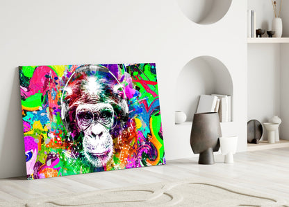 Colorful pop art glass panel featuring a smiling chimpanzee wearing headphones, displayed leaning against white wall beside minimalist decor.