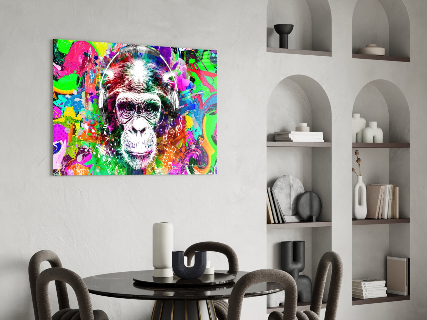 Colorful pop art monkey face glass wall art displayed above a round black dining table with gray chairs in a modern interior setting.