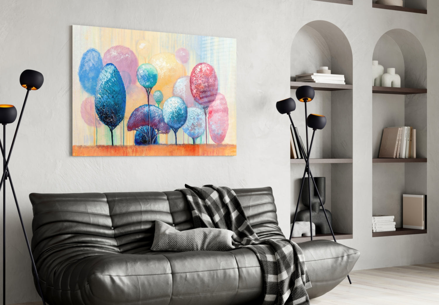 Colorful glass wall art depicting blue, pink, and yellow trees displayed above a black leather sofa in a modern living room.