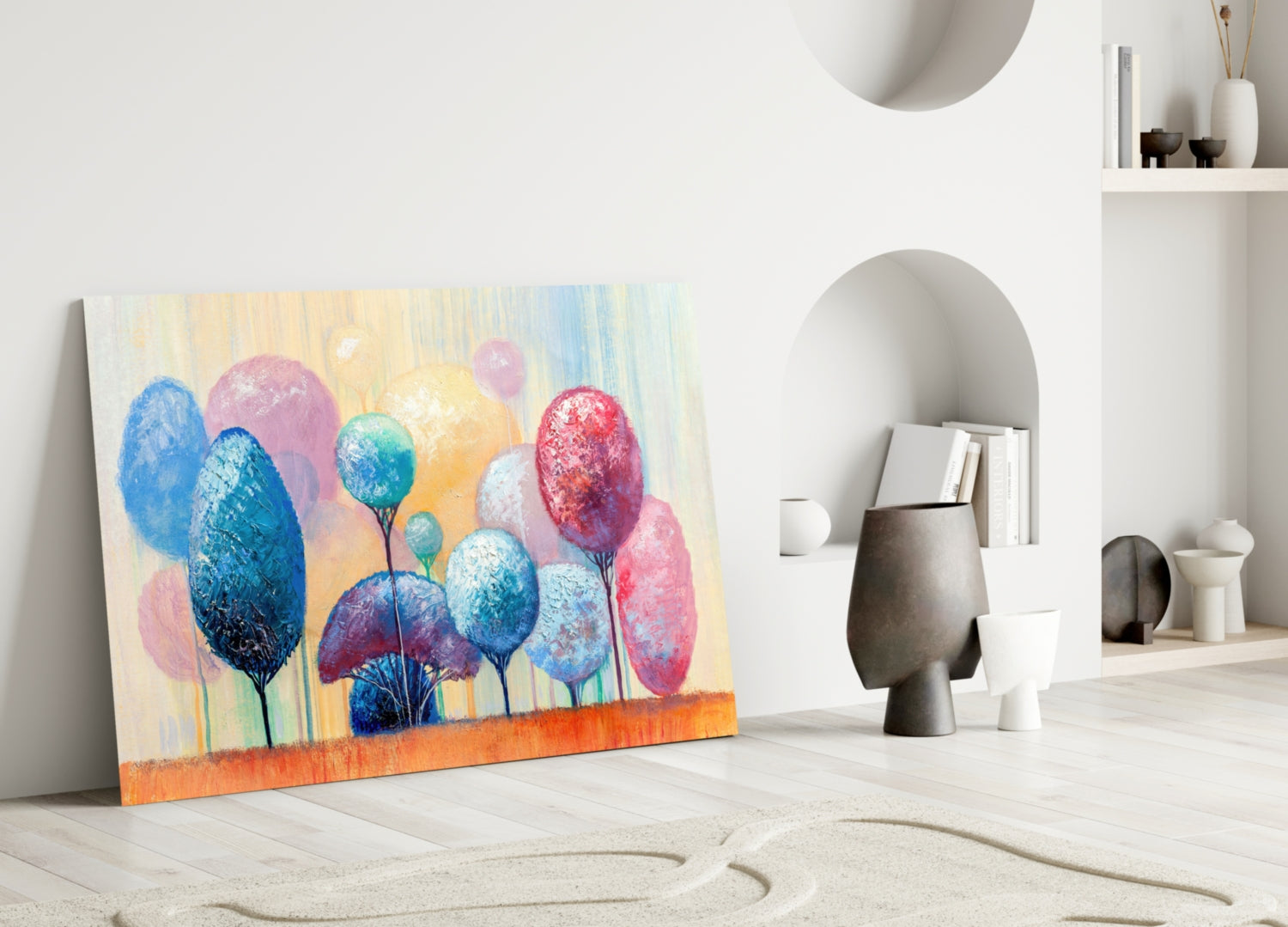 Colorful glass wall art depicting blue, pink, and red trees leaning against white interior wall with ceramic vessels and shelving.