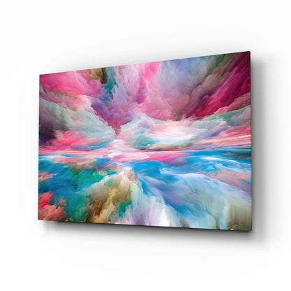 Glass wall art panel displaying an abstract landscape with swirling pink, blue, turquoise, and white clouds, shown at an angled perspective.