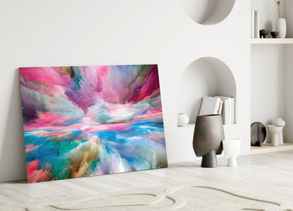 Colorful glass wall art leaning against white wall in minimalist interior with sand and ceramic decor.