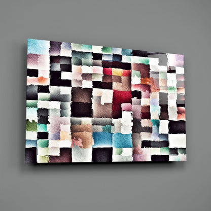 Abstract glass wall art panel featuring a pixelated mosaic of watercolor-effect squares in multicolored hues including black, white, pink, teal, and brown, displayed at an angled perspective.
