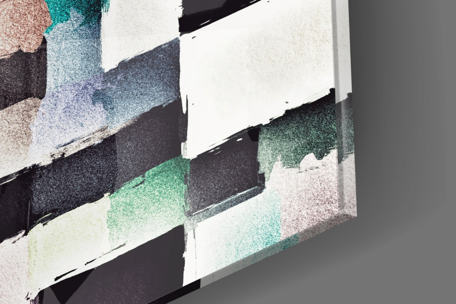 Close-up of glass wall art displaying textured paint strokes in green, black, white, and beige on angled transparent panels.