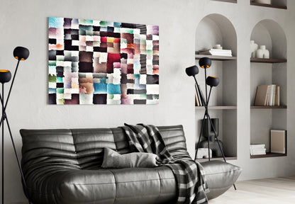 Modern living room interior with colorful pixelated glass wall art above black leather sofa and white built-in shelving.