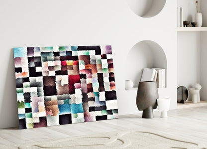 Colorful patchwork glass wall art leaning against white wall in minimalist room with decorative objects and curved alcoves.
