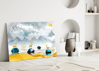 Glass wall art leaning against white wall displays golden deer, blue stones, mountains, yellow sun, and flying birds in misty landscape.