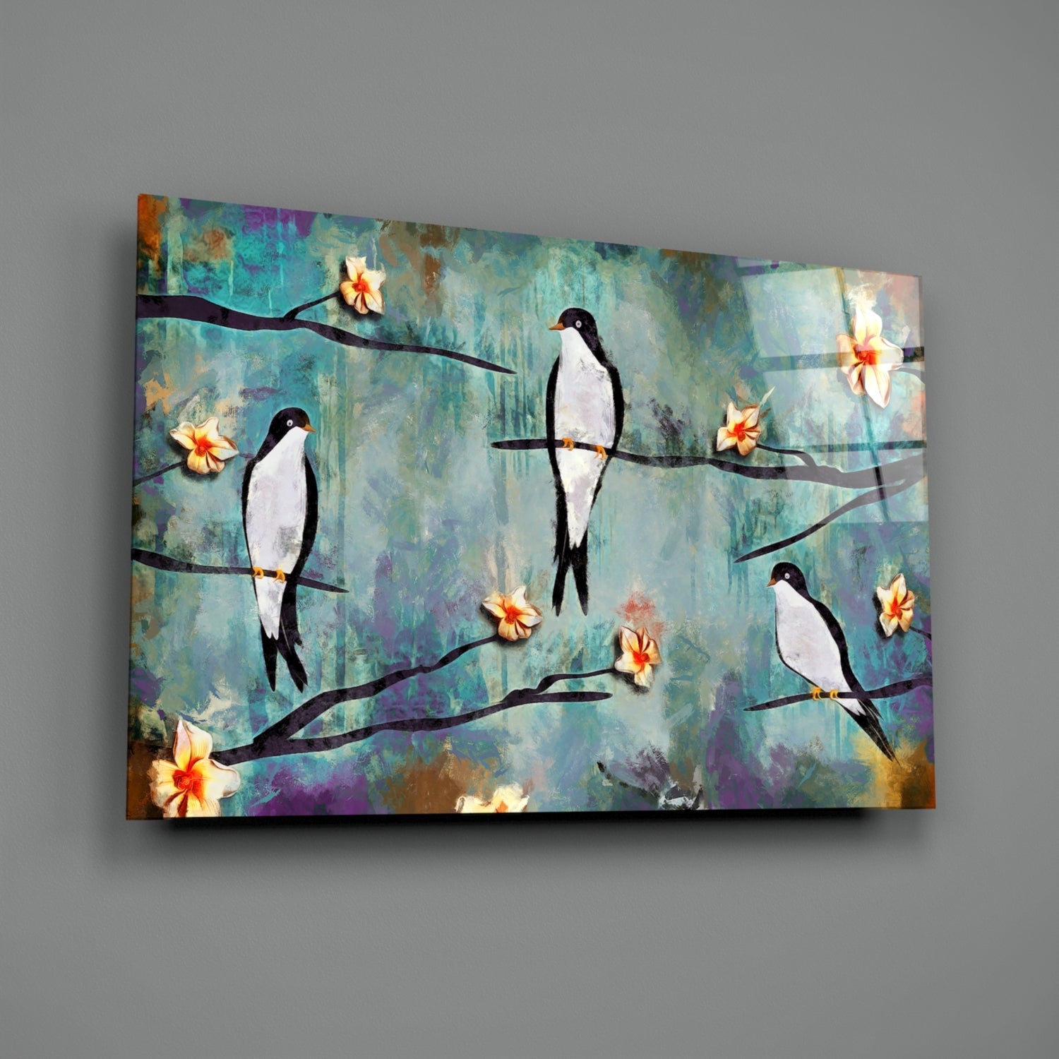 Glass wall art panel displaying stylized black and white birds perched on branches with yellow flowers against textured turquoise and purple background.