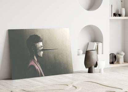 Glass wall art depicting a profile of a man with an elongated nose, displayed leaning against a white wall in a minimalist interior setting.
