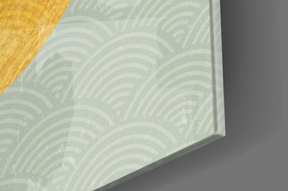 Close-up of frosted glass surface featuring white and pale green repeating arc pattern, photographed at an angle against wooden and gray surfaces.