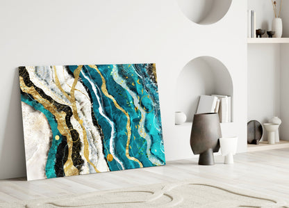 Marble Waves glass wall art leaning against white wall displaying turquoise, gold, black and white abstract marble pattern in minimalist interior setting.