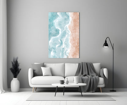 Beach glass wall art depicting turquoise ocean waves and white foam on sandy beach displayed above white sofa in modern living room.