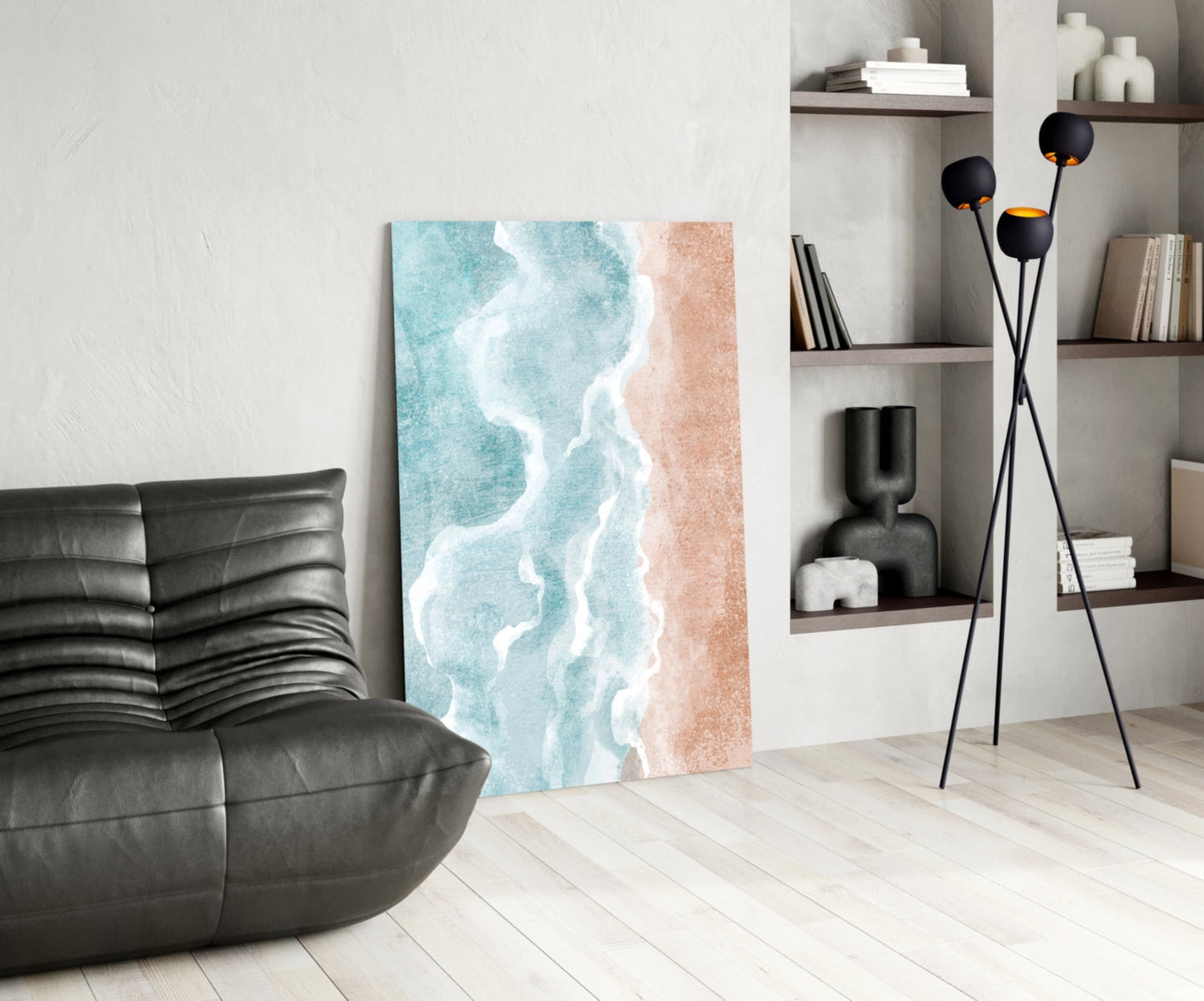Beach-themed canvas artwork featuring turquoise ocean waves and sandy beach in modern living room setting with black furniture and shelving.