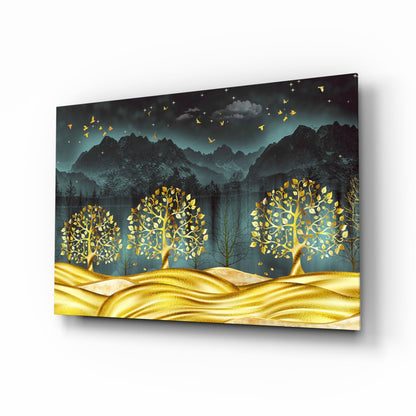Angled view of glass wall art showing golden trees with glowing leaves against dark mountains and teal sky with flying birds.