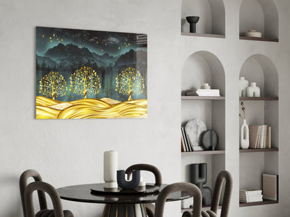 Golden forest glass wall art with luminous trees and mountains displayed above a black dining table in a modern interior setting.