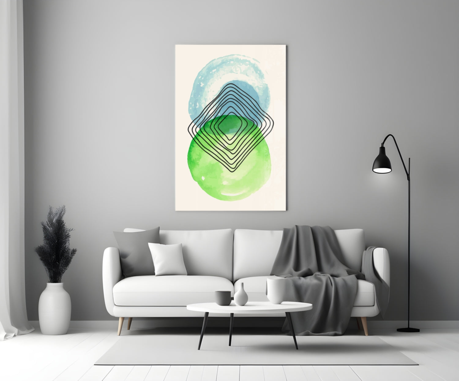 Abstract wall art with concentric diamond shapes in blue, green, and black on cream background, displayed above a white sofa in a modern living room.