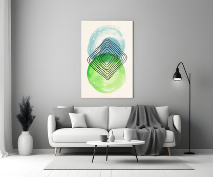 Abstract wall art with concentric diamond shapes in blue, green, and black on cream background, displayed above a white sofa in a modern living room.