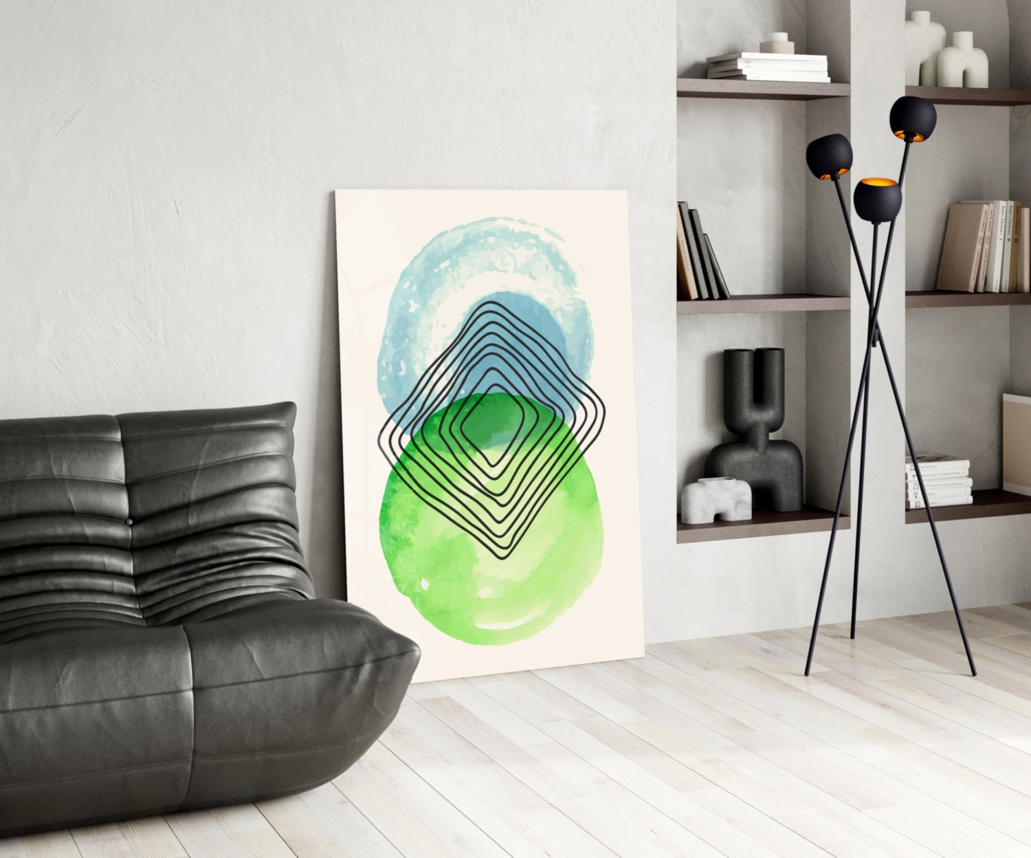 Modern living room interior featuring abstract glass wall art with blue and green watercolor ovals and black concentric line patterns displayed leaning against white wall.