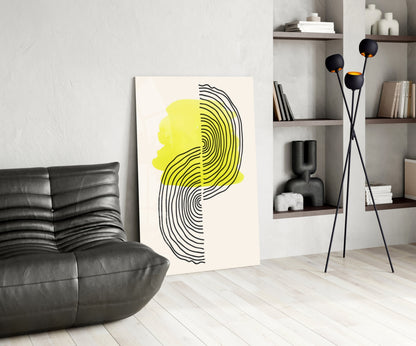 Abstract sun glass wall art featuring yellow and black line-drawn profile displayed in modern living room with leather sofa and shelving.