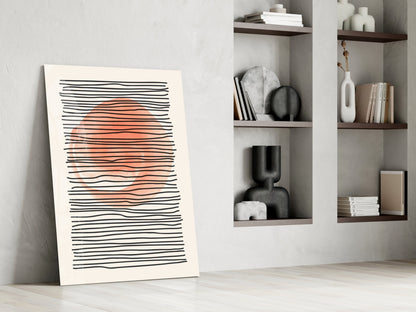 Abstract art print leaning against wall featuring horizontal black lines with coral-orange sun shape, displayed in minimalist interior setting.