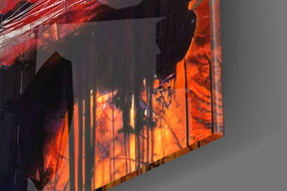 Angled close-up of illuminated glass panel displaying warm orange and red tones with silhouetted figure and vertical line patterns.