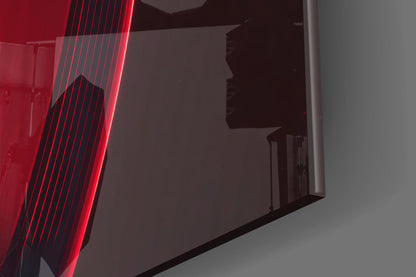 Red neon-lit glass panel with vertical lines beside dark silhouetted gramophone design on gray wall.
