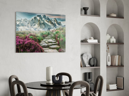 Glass wall art depicting snow-capped mountains and purple flowering path displayed above black dining table in modern interior.