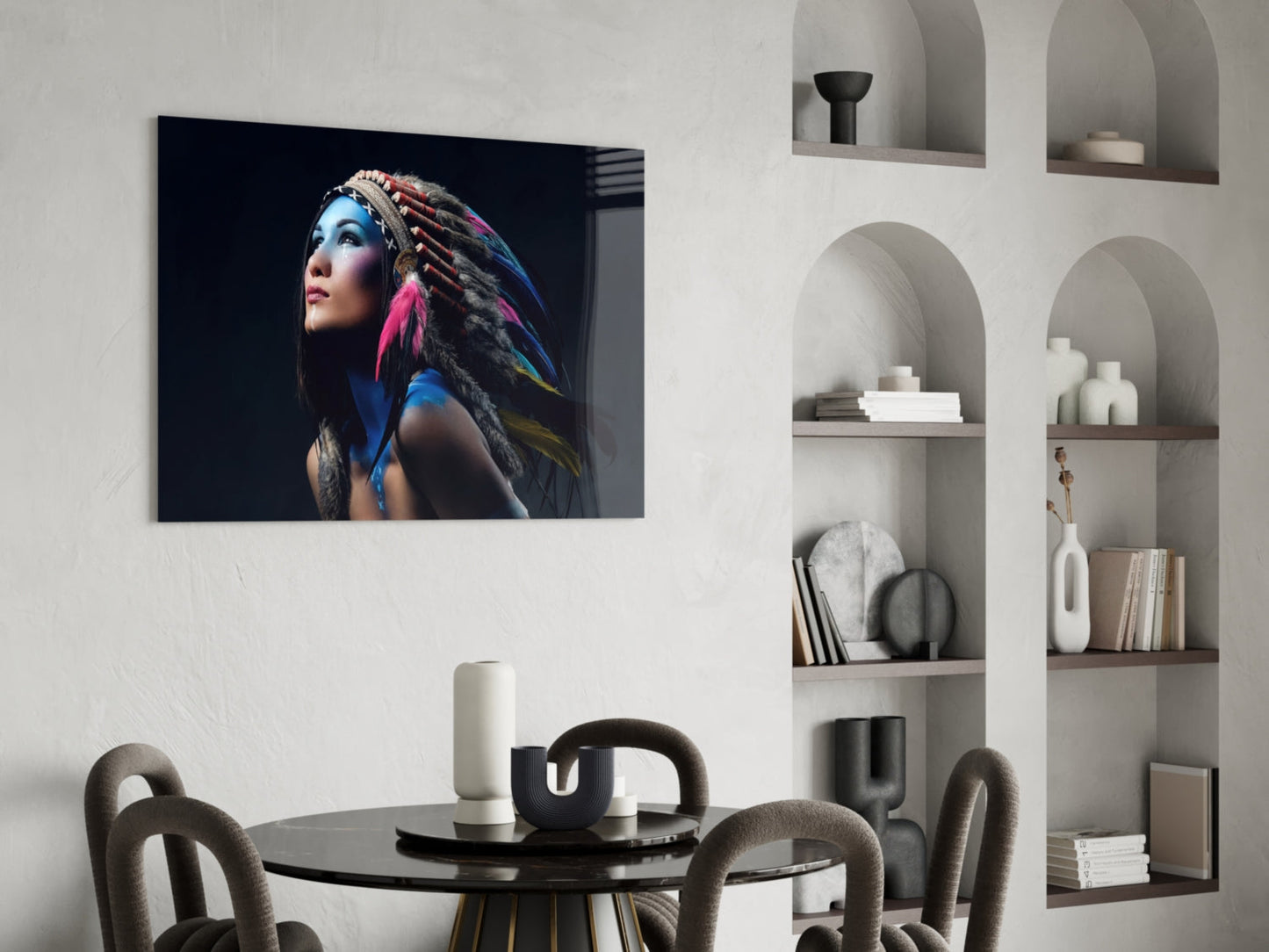 Glass wall art featuring portrait of woman with blue face paint and colorful feathered hair against black background, displayed in modern dining room setting.