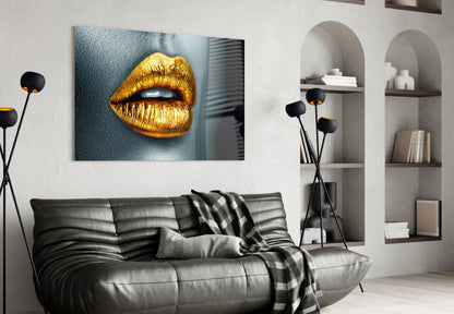 Golden lips glass wall art displayed above a black leather sofa in a modern living room with white shelving.