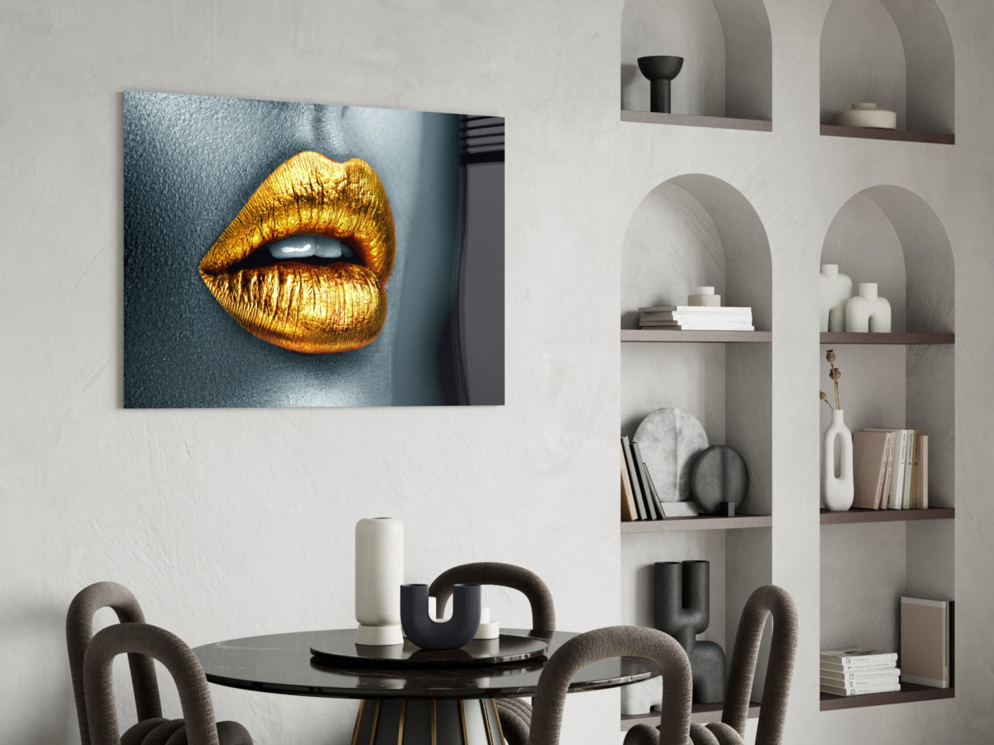 Golden lips glass wall art displayed above a black round dining table in a modern interior with built-in shelving.