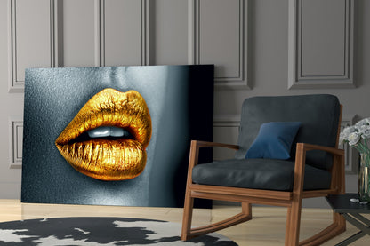 Golden Lips Glass Wall Art displayed in modern living room with mid-century wooden chair and gray paneled wall.