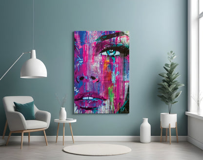 Vibrant pop art canvas depicting a woman's face in magenta, blue, and neon colors displayed on a teal wall in a modern living room setting.