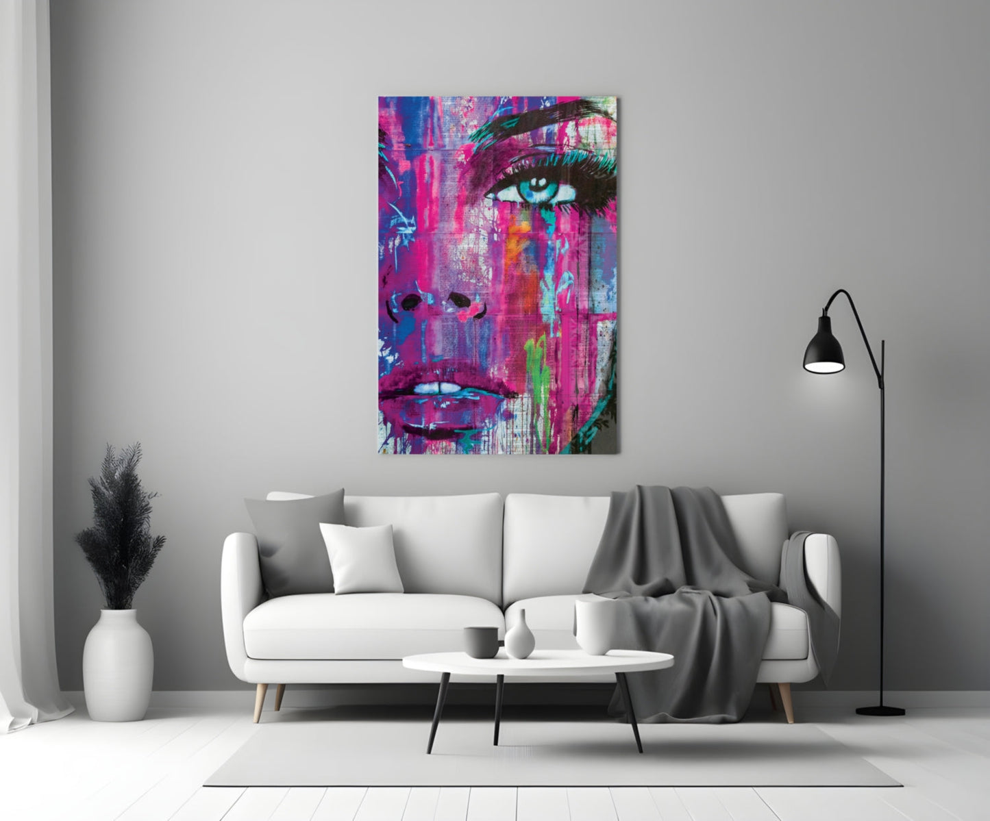 Vibrant pop art portrait with pink, blue, and neon colors displayed above a white sofa in a modern living room setting.