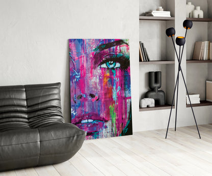 Vibrant pop art portrait canvas featuring a woman's face in magenta, blue, and neon colors displayed in a modern living room setting.