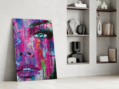 Vibrant pop art canvas featuring a woman's face in magenta, blue, and neon colors leaning against white wall beside shelving.