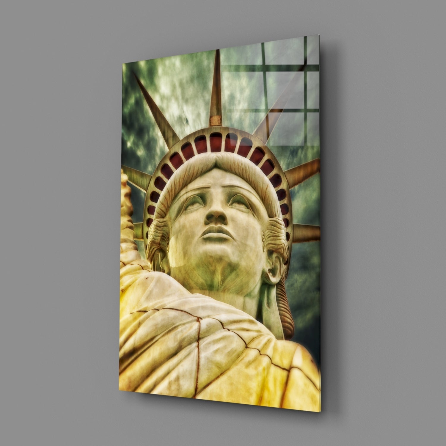 Close-up of Statue of Liberty face and crown on glass wall art panel with yellow robe and green background.