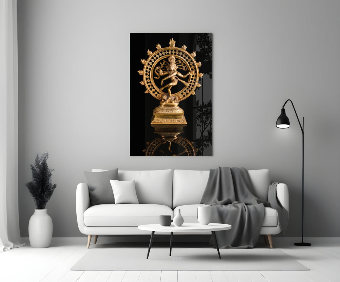 Golden Shiva Nataraja statue displayed on white living room wall above cream sofa with black background.