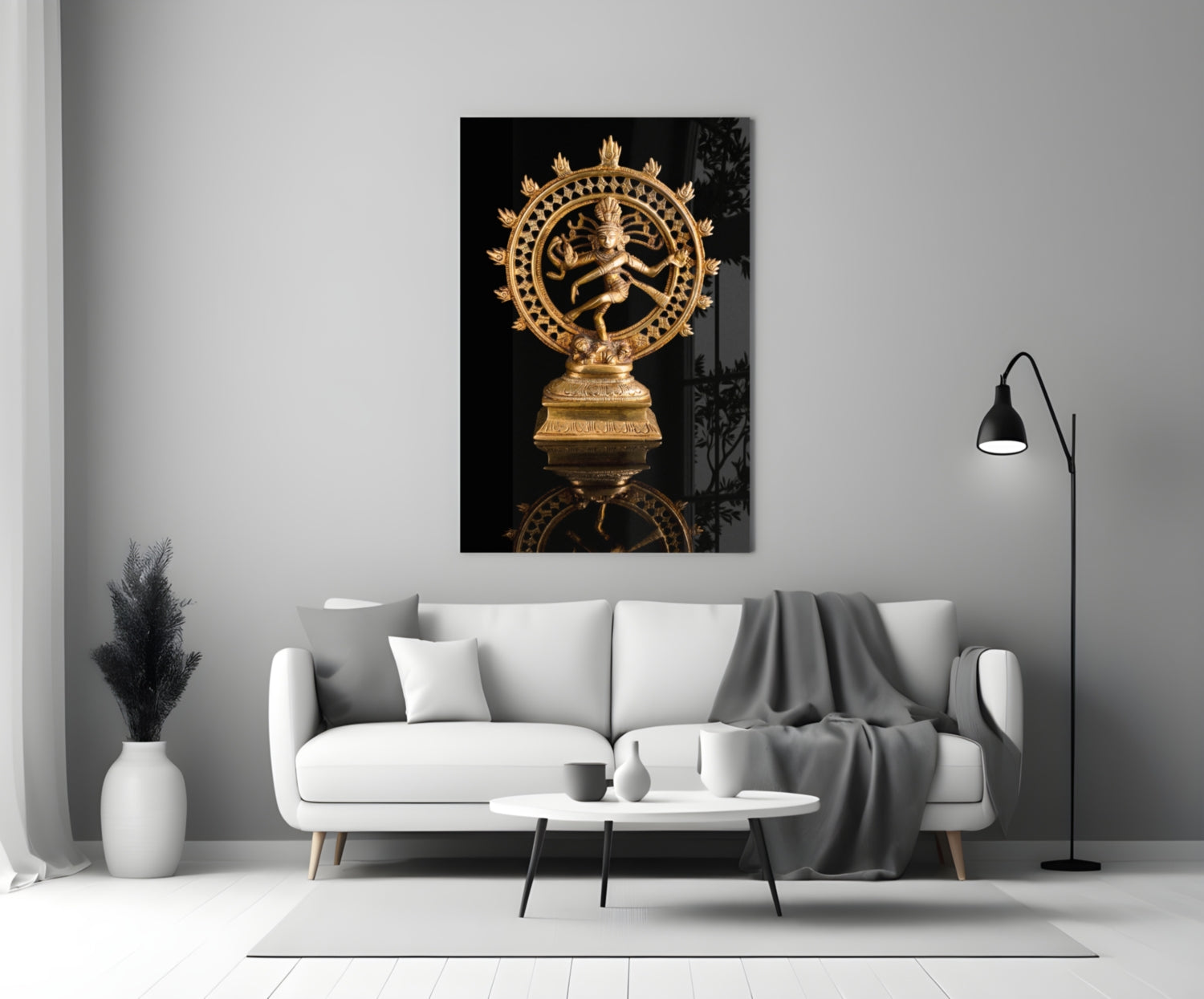 Golden Shiva Nataraja statue displayed on white living room wall above cream sofa with black background.