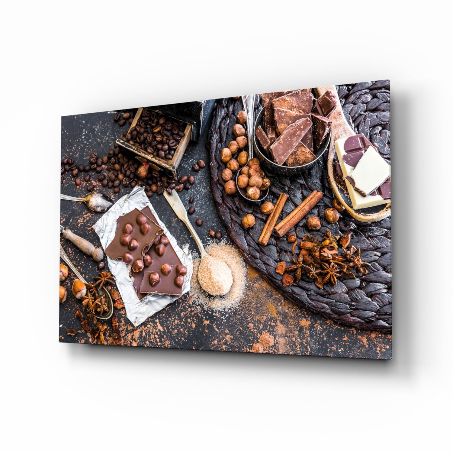 Chocolate glass wall art displaying overhead flat lay of chocolate pieces, coffee beans, hazelnuts, cinnamon sticks, and star anise on dark textured background.