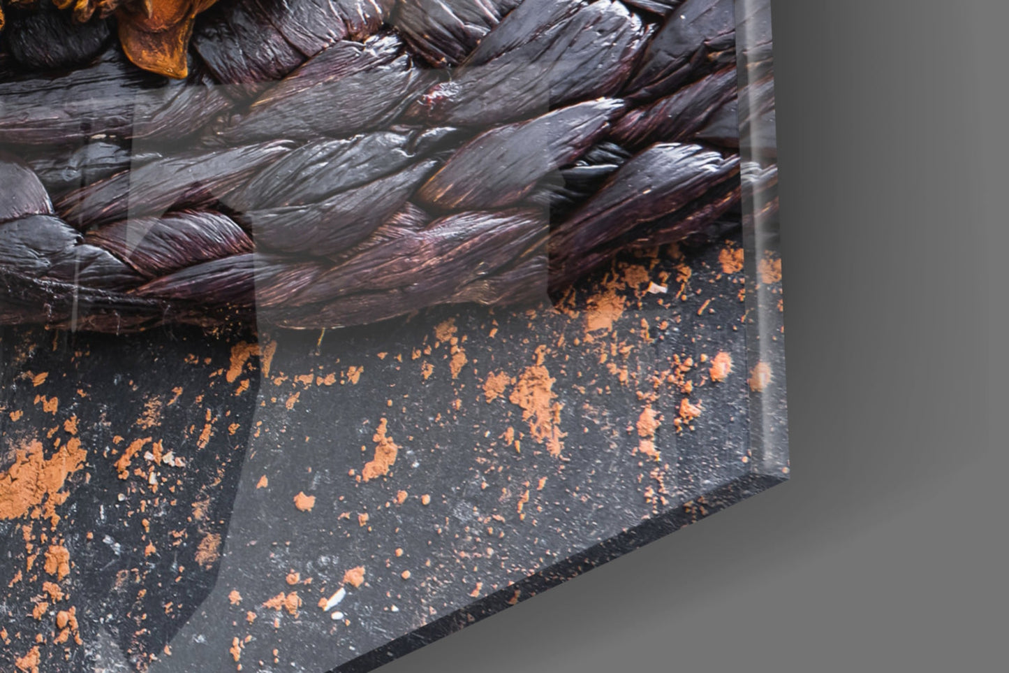 Close-up detail of chocolate glass wall art showing textured dark brown and black surface with copper-colored splatter accents against gray background.