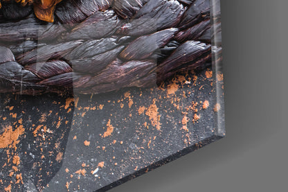 Close-up detail of chocolate glass wall art showing textured dark brown and black surface with copper-colored splatter accents against gray background.
