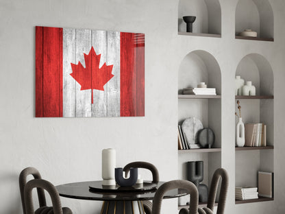 Canadian flag glass wall art with red and white maple leaf design displayed above round black dining table with modern chairs.