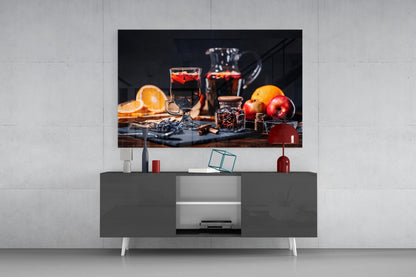 Noel Tea Glass Wall Art displayed above a gray media console, showing a still life of beverages, citrus fruits, and apples on dark background.