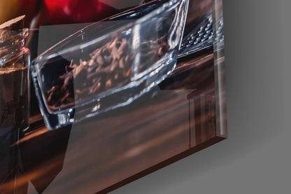 Close-up angled view of translucent glass wall art with warm amber and brown tones, showing curved edge detail against neutral background.
