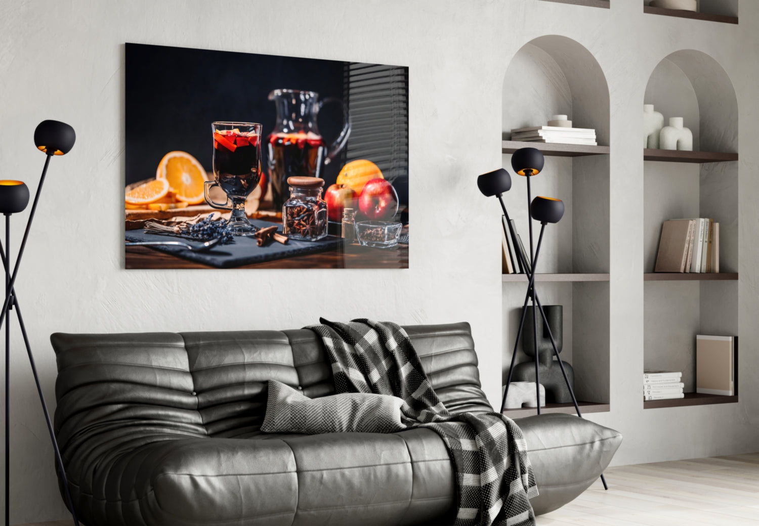 Modern living room featuring black leather sofa with Noel Tea Glass Wall Art displaying cocktails, citrus, and apples above.